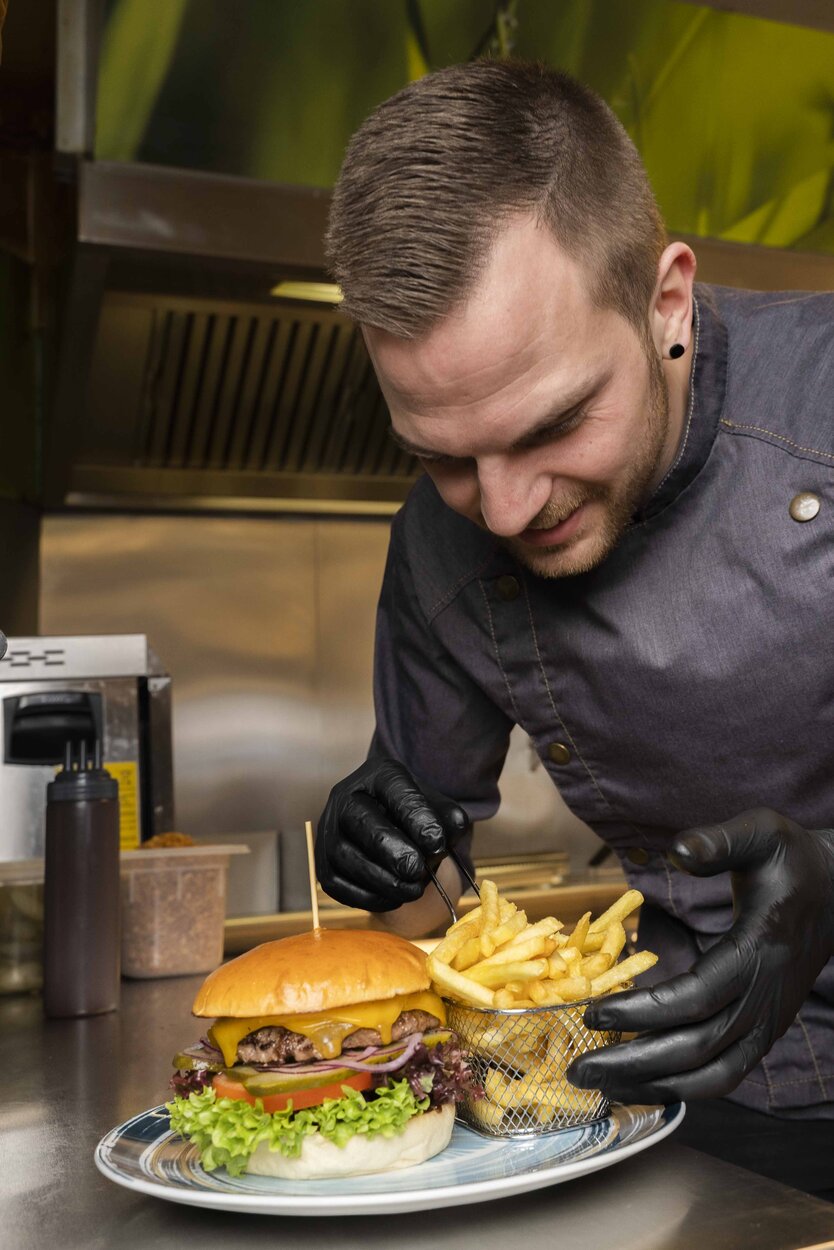 Marcel beim Burger garnieren | © Das ZoO / Gassner Gastronomie